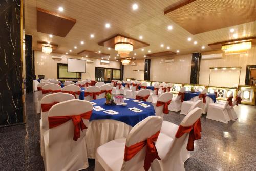 a banquet hall with white tables and red bows at Foxoso Fiori Hotel in Jaipur