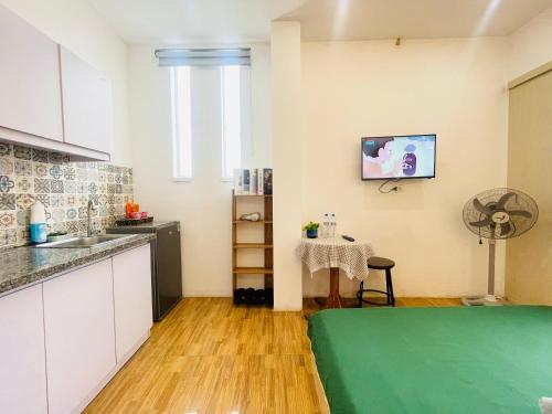 a kitchen with a table and a small kitchen with a laptop at Libré Homestay in Hanoi