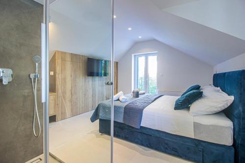 a bedroom with a bed and a glass shower at Villa Lota - Makarska Exklusiv in Baška Voda