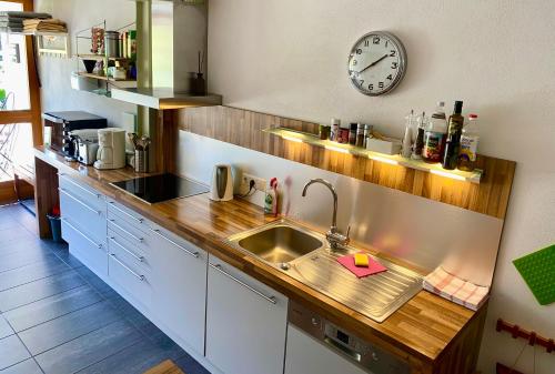 a kitchen with a sink and a clock on the wall at Pauls Huesle in Gargellen