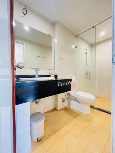 a bathroom with a sink and a toilet and a mirror at Libré Homestay in Hanoi