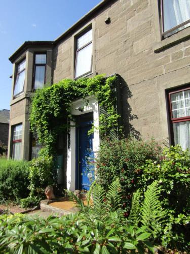 a brick house with a blue door at Athollbank Guest House in Dundee