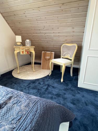 a bedroom with a bed and a table and a chair at Mowennest Morsum in Morsum