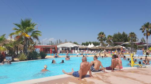 Un grupo de personas en la piscina de un resort. en Le Montourey mobihome, en Fréjus