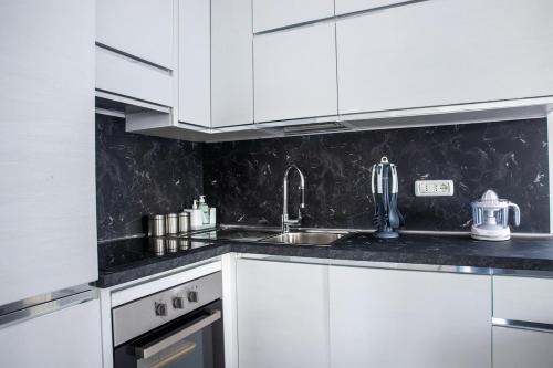 a kitchen with white cabinets and a sink at Tornolo, 5 Stelle - Alloggio Elegante in Tornolo