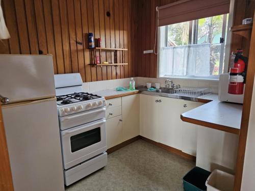 a kitchen with a white stove and a refrigerator at Fletcher Christian Apartments - Isabella Suites in Burnt Pine