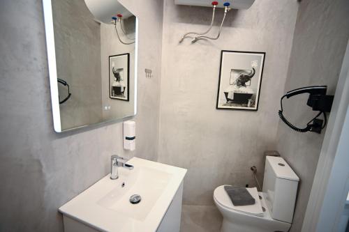 a bathroom with a sink and a toilet and a mirror at Syntagma Plaka Suite by Zeussuites in Athens