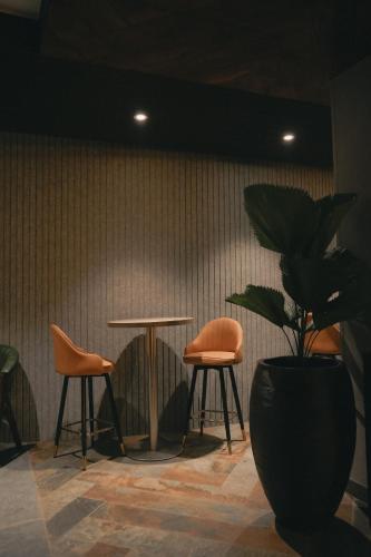 a table and two chairs and a potted plant at Menaka inn in Dhārwād