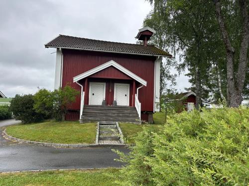 a small red house with a porch and stairs to it at Cozy 2 bedroom house on a farm just outside Lillestrøm in Lillestrøm