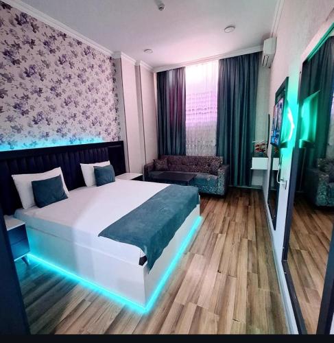 a bedroom with a large white bed and a couch at Nord West Hotel in Baku