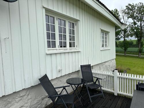 a patio with chairs and a table and a window at Cozy 2 bedroom house on a farm just outside Lillestrøm in Lillestrøm