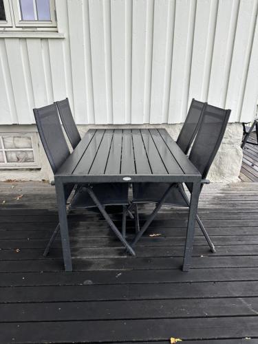 a picnic table and two chairs on a deck at Cozy 2 bedroom house on a farm just outside Lillestrøm in Lillestrøm