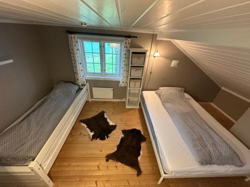 two beds in a small room with a window at Cozy 2 bedroom house on a farm just outside Lillestrøm in Lillestrøm