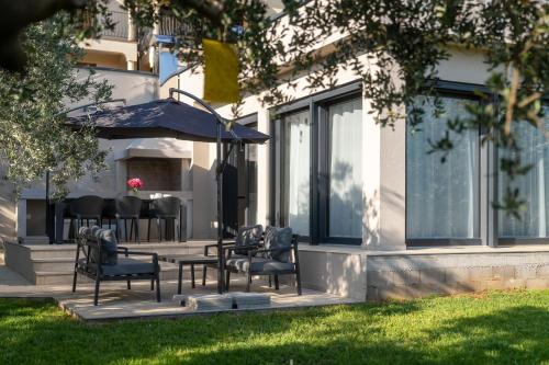 a group of chairs and an umbrella on a patio at Vila Aurora in Vrsar