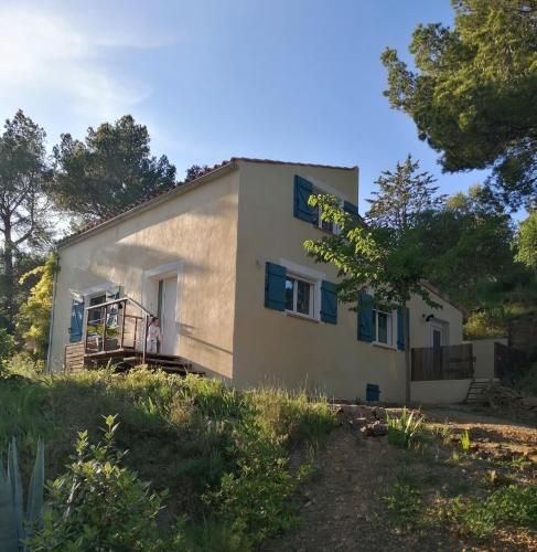 a small white house with a person standing outside of it at Maison dans les Corbières in Montséret