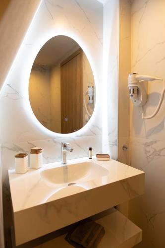 a bathroom with a sink and a mirror at Mple Boutique Suites in Ouranoupoli