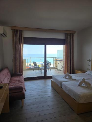 a hotel room with two beds and a view of the ocean at APARTMENTS by the SEA in Leptokarya