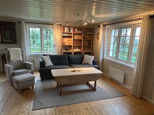 a living room with a couch and a chair and a coffee table at Cozy 2 bedroom house on a farm just outside Lillestrøm in Lillestrøm
