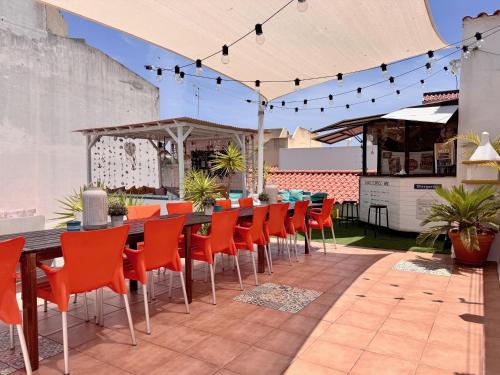 an outdoor patio with a long table and chairs at Orange Terrace Hostel in Albufeira