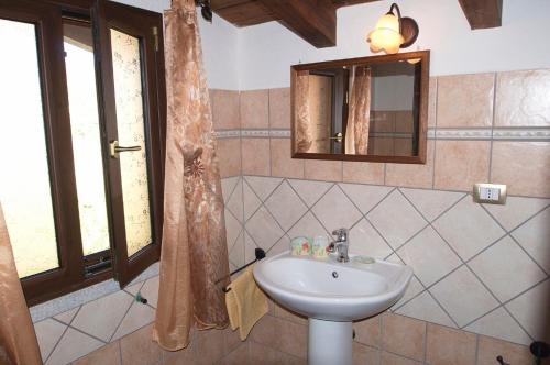 een badkamer met een wastafel en een spiegel bij Villetta Bouganvillea in SantʼAnna Arresi