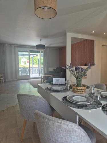 a dining room and living room with a table and chairs at Maison familiale lavande in Thiais