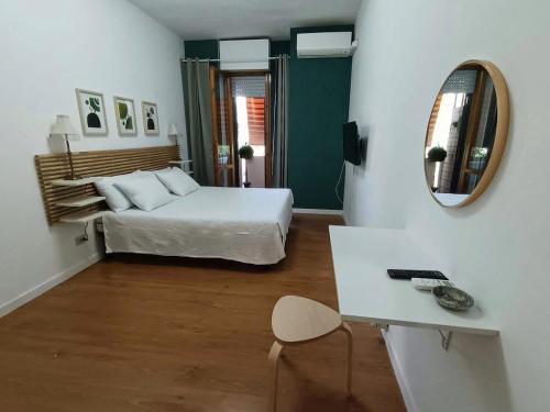une chambre avec un lit, un bureau et un miroir dans l'établissement Bed & Movie, à Rome