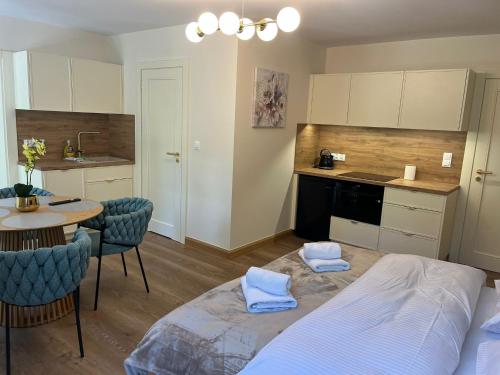 a bedroom with a bed and a table and a kitchen at Apartamenty Leśna Przystań Kazub nr 11 in Cieciorka