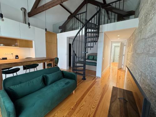 a living room and kitchen with a green couch at Porto Suites in Porto
