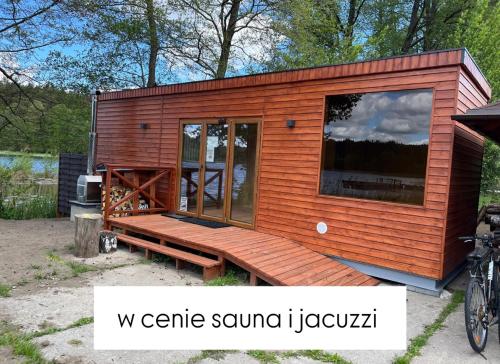 a tiny house with a large window and a bench at Apartamenty Leśna Przystań Kazub nr 11 in Cieciorka
