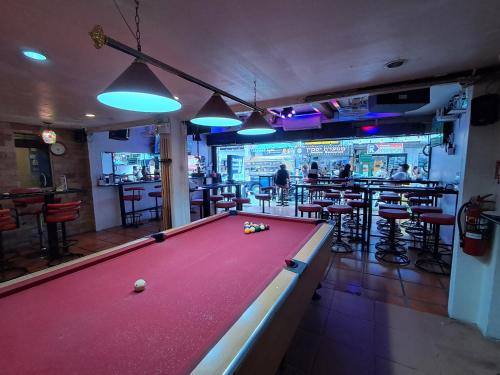 a pool table in a room with a bar at Namtip Bar & Guesthouse in Pattaya
