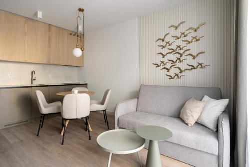 a living room with a couch and a table at Rezydencja Merwede Aparthotel - My Rest in Gdańsk