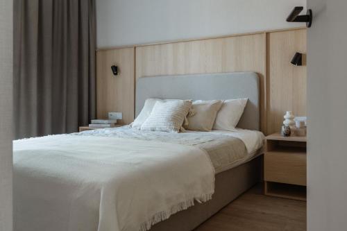 a bedroom with a large bed with white sheets and pillows at Rezydencja Merwede Aparthotel - My Rest in Gdańsk