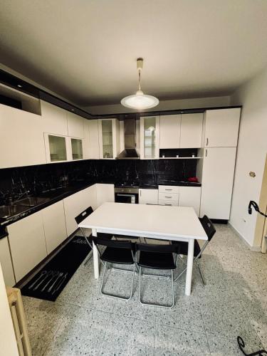 a kitchen with a white table and chairs at Villa Madonnina in riva al fiume Tirino in Bussi sul Tirino