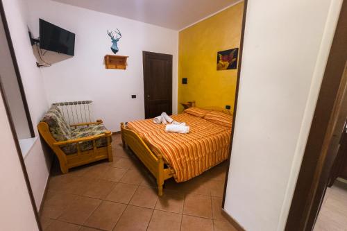 a bedroom with a bed and a chair and a mirror at la locanda del carrettiere in Casavecchia