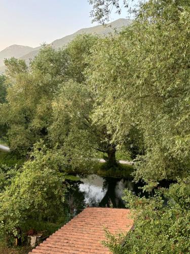 a tree with a brick roof next to a river at Villa Madonnina in riva al fiume Tirino in Bussi sul Tirino
