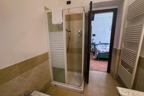 a shower with a glass door in a bathroom at la locanda del carrettiere in Casavecchia