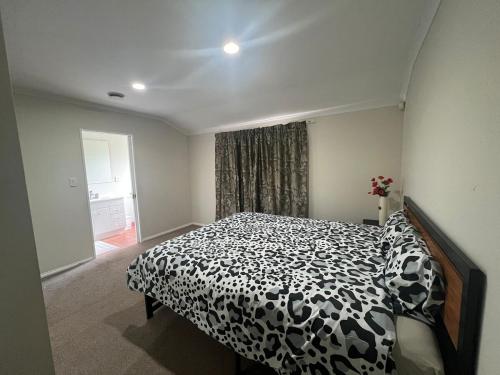 a bedroom with a black and white bed with a window at Best aboard on Chapel Road in Auckland