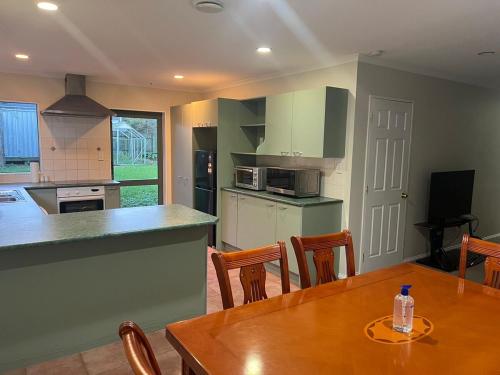 a kitchen and dining room with a wooden table at Best aboard on Chapel Road in Auckland