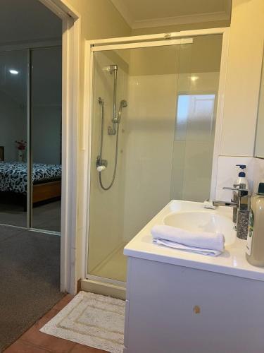 a bathroom with a shower and a sink and a mirror at Best aboard on Chapel Road in Auckland