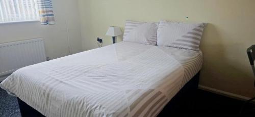 a bed with white sheets and pillows in a bedroom at Nice Residential Within Easy Reach Of Town in Manchester
