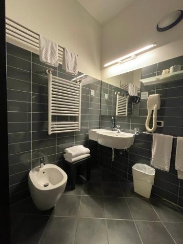 a bathroom with a sink and a toilet and a bidet at Hotel Cristallo in Rimini