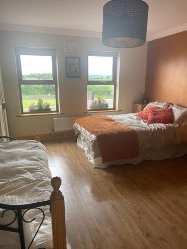 a bedroom with a bed and two windows at Homestay Large Ensuite Room in Balnacart