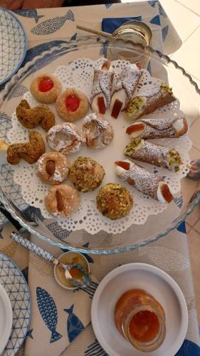 un piatto di diversi tipi di prodotti da forno su un tavolo di Sicilia Meraviglia B&B a Fontane Bianche