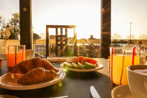 a table with two plates of food and oranges and drinks at Alevic Hotel Sirmione in Sirmione
