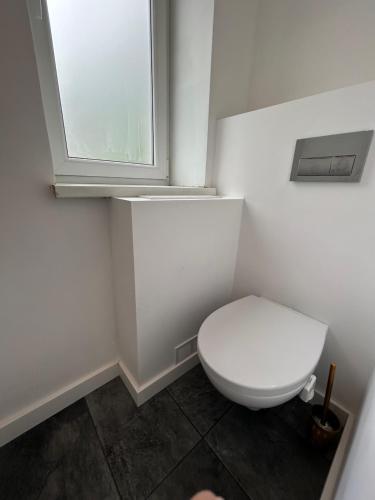 Un baño blanco con inodoro y ventana. en Kauguri Breeze, en Jūrmala