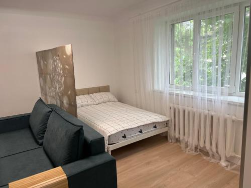 Habitación pequeña con sofá y ventana en Kauguri Breeze, en Jūrmala