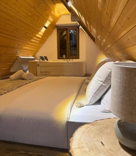 a bedroom with a large bed with a wooden ceiling at Valter & Drita's Guesthouse in Theth
