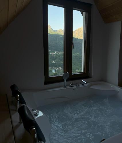 a bath tub in a bathroom with a window at Valter & Drita's Guesthouse in Theth