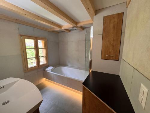 a bathroom with a bath tub and a sink at Wonderful Apartment with Lake View in Oberried