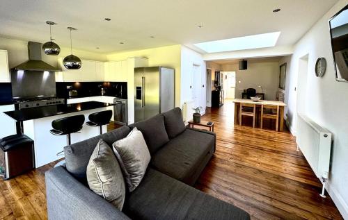 a living room with a couch and a kitchen at Spacious 4 beds house with FAST WIFI and FREE PARKING ideal for businesses, visiting family or relocation in Hatfield